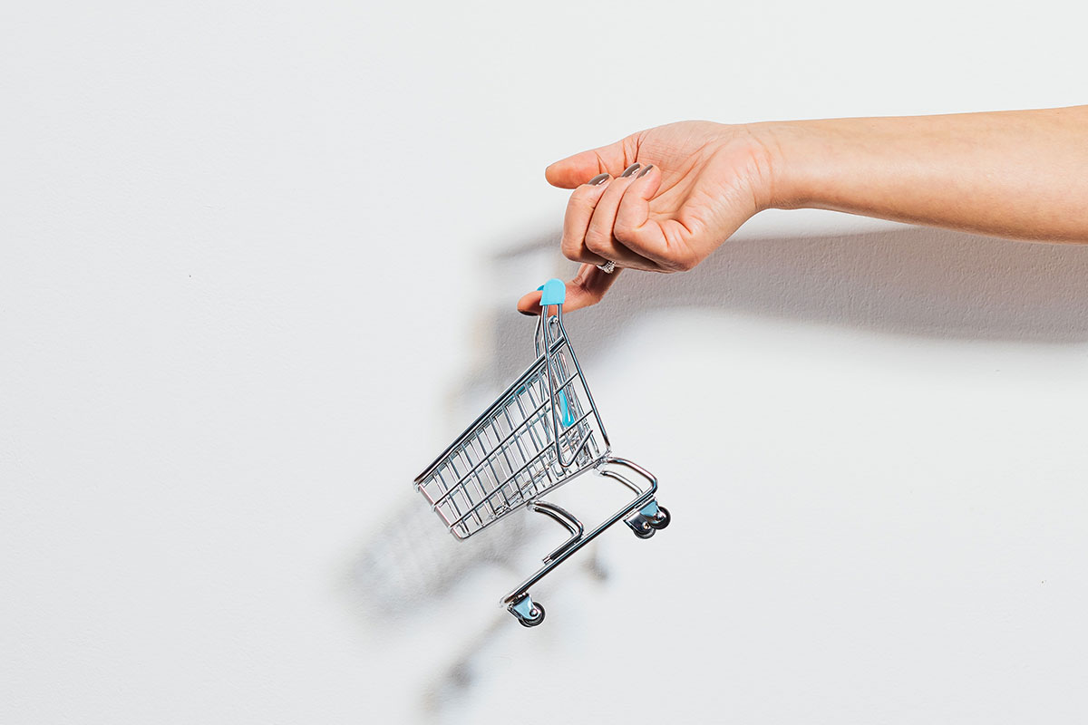 Mão a segurar um carrinho de compras