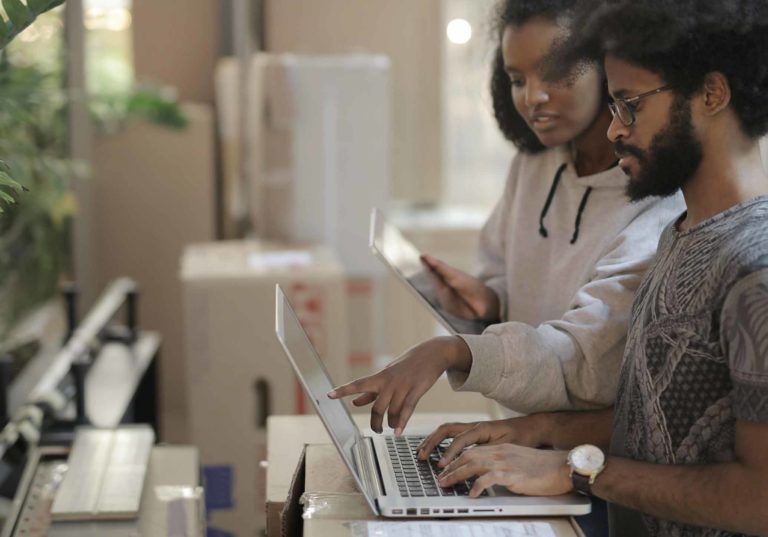 Jovens a usar laptop e tablet num espaço de trabalho