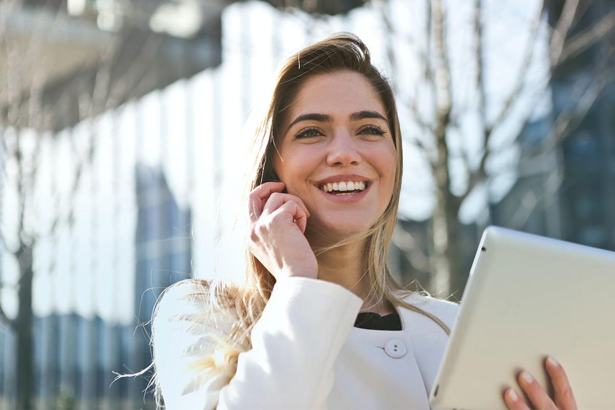 Mulher com tablet a falar pelo telemóvel