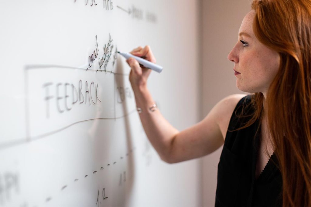 Jovem empreendedora a escrever no quadro