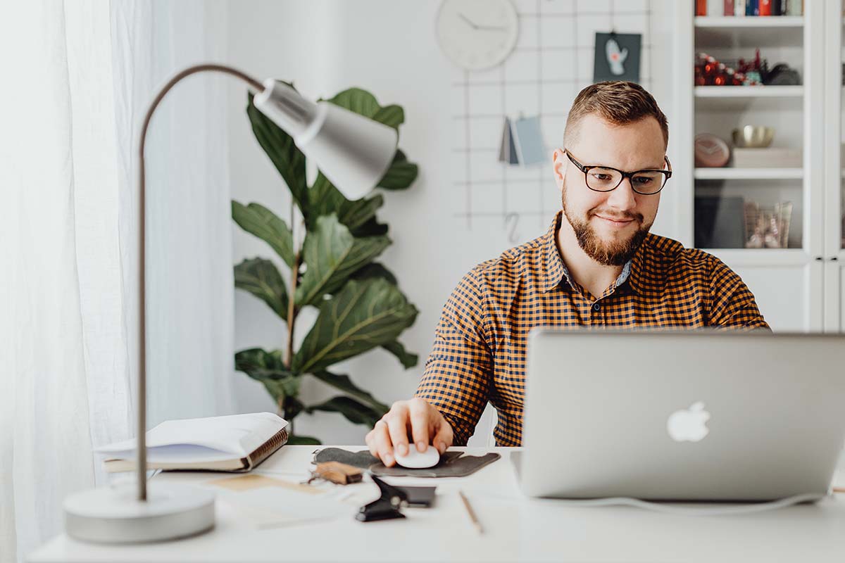Jovem na secretária a trabalhar no laptop